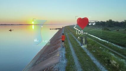 Athletic male jogger runs along lake shore at sunset and uses sports app to display health data and statistics on heart rate and a map. Digital overlay infographics