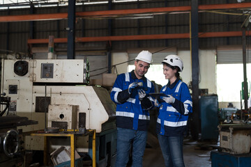 Male and female engineer working in industry factory, discussing together of work on digital...
