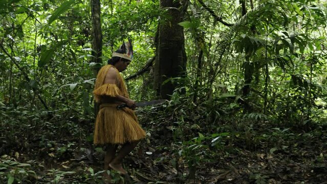 Portrait of an indigenous man carrying a machete through the dense jungle in Leticia, Amazon, Colombia