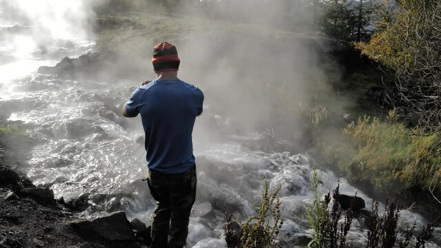 Man taking photos of the steaming river in Iceland