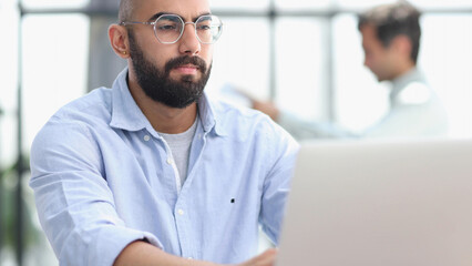 Businessman working on the table with laptop in a new office