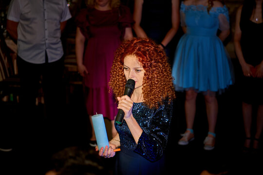 Host of a wedding ceremony, festive event with a candle,microphone - Powered by Adobe