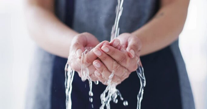 Closeup, woman and hands with water for washing in bathroom for hygiene, cleanliness or germs. Liquid drops, flow and hydration for bacteria with stream for wellness, natural health and self care