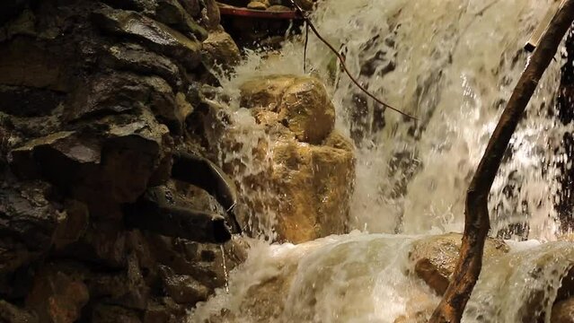 Dirty mountain river after heavy rain in the mountains, cascading waterfall