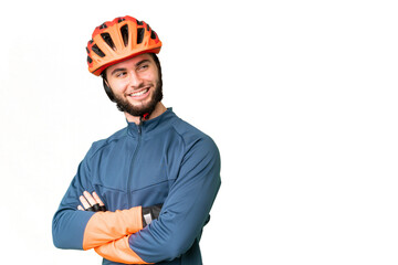 Young cyclist man over isolated chroma key background with arms crossed and happy