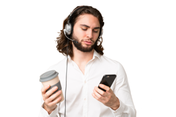 Telemarketer man working with a headset over isolated chroma key background holding coffee to take away and a mobile