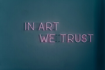 Neon sign on the wall. Neon sign with the words in art we trust