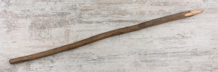 primitive wooden spear on wooden background