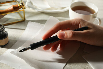 A man writes a love letter with an antique pen