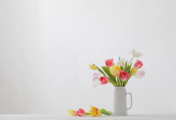 beautiful   tulips in white jug on white background