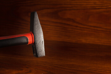 Hammer close-up on a wooden background. The background is blurry. Tool for home repairs and assembling wooden products.