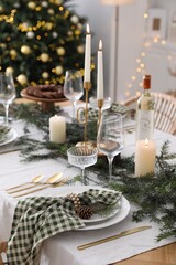 Christmas table setting with festive decor and dishware in room