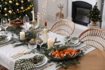 Christmas table setting with festive decor and dishware in room