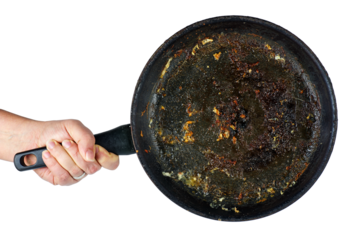 Hand hold frying pan with the leftover grease isolated on a white background.
