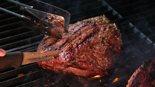 cooking steaks on the fire in real Close-up view of juicy cooked slices of meat with flames. original dish recipe. Professional cooking, food recipe, cooking. Horizontal . Top view.