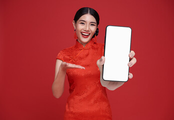 Happy Beautiful chinese Asian woman holding smartphone mockup and pointing finger blank screen and...