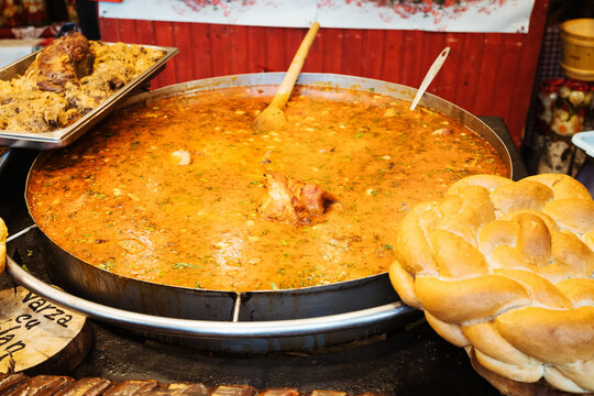Traditional Romanian dishes from winter market in Timisoara Romania - Fasole cu Carnati (smoked sausages with beans stew) and deep-fried cheese