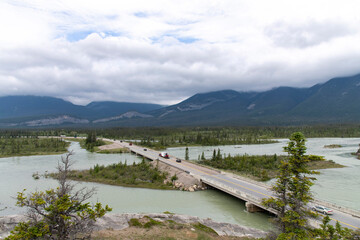 Fototapeta na wymiar High angle view of the Yellowhead Highway with light traffic crossing the Athabasca River near Jasper, AB, Canada