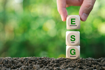ESG concept.Environmental, Social and Governance.Hand holding wood block with ESG words on green background for sustainable organizational development. - obrazy, fototapety, plakaty
