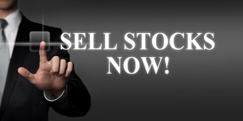 sell stocks now - businessman pressing virtual touchscreen button