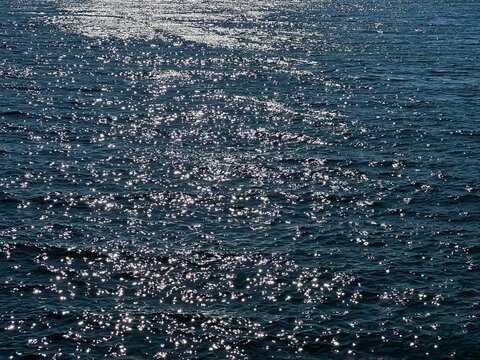 Blue sea water glittering shiny surface.
