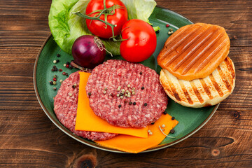 Raw hamburger patties on wooden background.