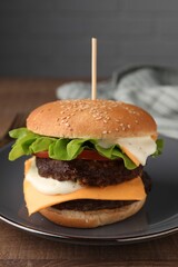 Tasty cheeseburger with patties on wooden table, closeup