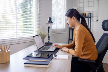 Young business asian woman work on laptop desk doing math finance on an office desk, tax, report,...