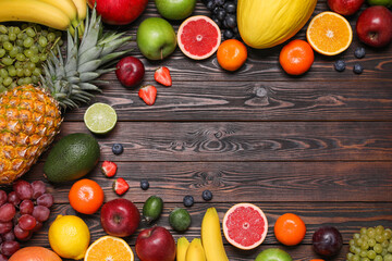 Different ripe fruits on wooden table, top view. Space for text