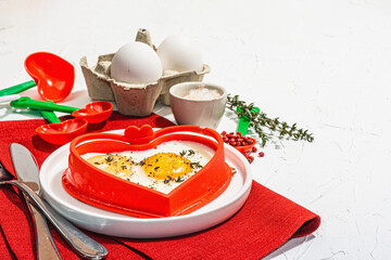 Heart-shaped fried egg served with toasted bread. Romantic art food idea for Valentine's breakfast
