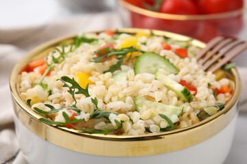 Fototapeta na wymiar Cooked bulgur with vegetables in bowl, closeup