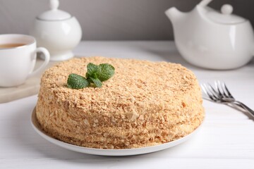 Delicious Napoleon cake served on white wooden table, closeup
