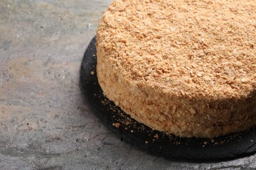 Delicious Napoleon cake on gray table, closeup. Space for text