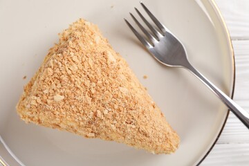 Piece of delicious Napoleon cake served on table, top view