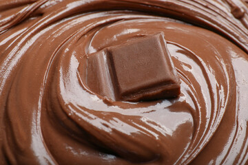 Tasty milk chocolate paste and piece as background, closeup