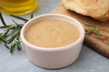 Delicious turkey gravy and rosemary on grey table, closeup