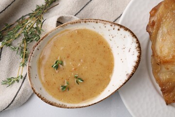 Delicious turkey gravy and thyme on white table, top view