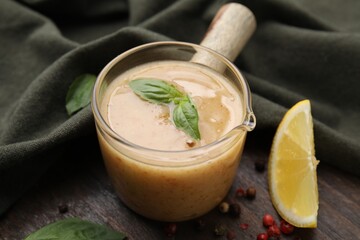 Delicious turkey gravy, basil, peppercorns and lemon on wooden table, closeup