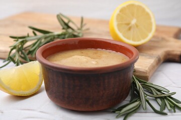 Delicious turkey gravy, rosemary and lemon on table, closeup