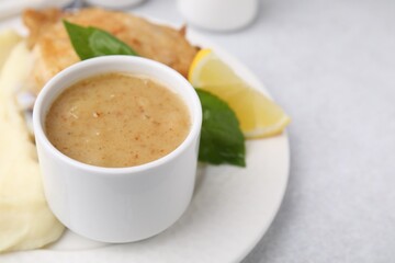 Delicious turkey gravy served on light grey table, closeup. Space for text