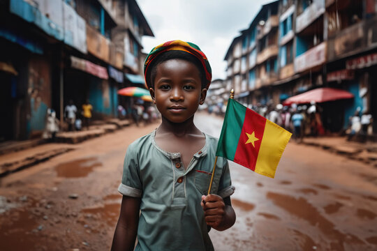 Cameroonian boy holding Cameroon flag in Douala street