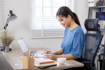 asian woman using calculator and calculate bills in home office. tax form us business income office Financial document. Tax time.Tax concept. - obrazy, fototapety, plakaty
