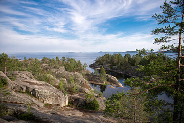 Fototapeta na wymiar Spruce forest on top of a cliff. Sheer cliffs on Ladoga skerries. Top view of the lake