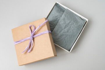 Open brown square craft gift box with ribbon. Space for text. Paper for packaging clothes, souvenirs