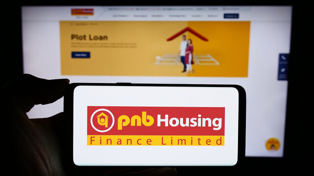 Stuttgart, Germany - 11-24-2023: Person holding cellphone with logo of Indian financial company PNB Housing Finance Limited in front of business webpage. Focus on phone display.