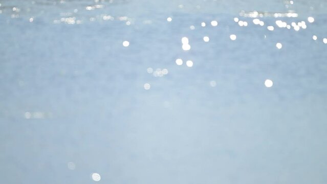 4K quality video of sunlight sparkles over moderate ocean waves on sunny day