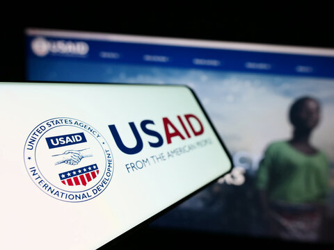 Stuttgart, Germany - 11-27-2023: Mobile phone with seal of United States Agency for International Development (USAID) in front of website. Focus on left of phone display.