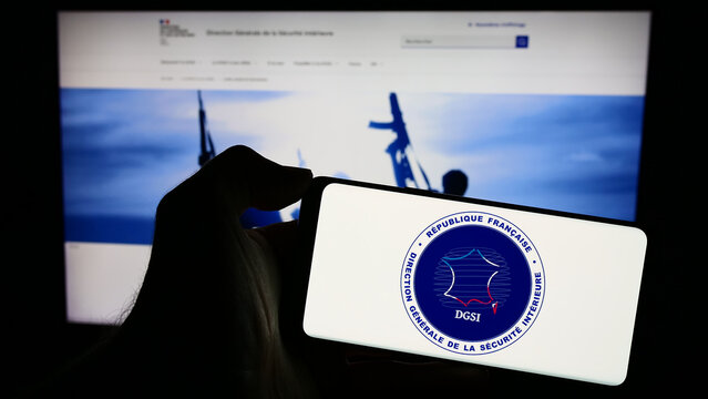 Stuttgart, Germany - 11-27-2023: Person holding cellphone with logo of Direction G&eacute;n&eacute;rale de la S&eacute;curit&eacute; Int&eacute;rieure (DGSI) in front of webpage. Focus on phone display.