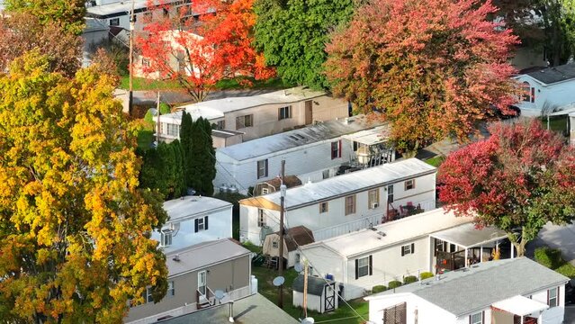 Mobile homes in suburb with autumn trees. Aerial view of trailer park with colorful foliage in fall.