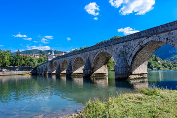 Fototapeta na wymiar Visegrad, Bosnia and Herzegovina - August 13, 2023: Famous bridge on the Drina in Visegrad, Bosnia and Herzegovina. Mehmed Pasa Sokolovic Bridge on Drina River